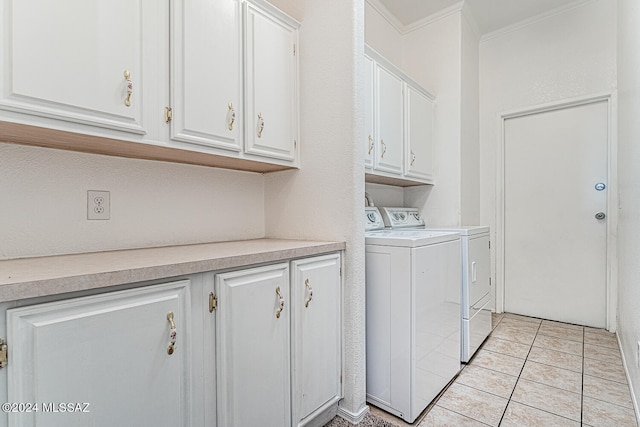 clothes washing area with ornamental molding, cabinets, light tile patterned floors, and washer and clothes dryer