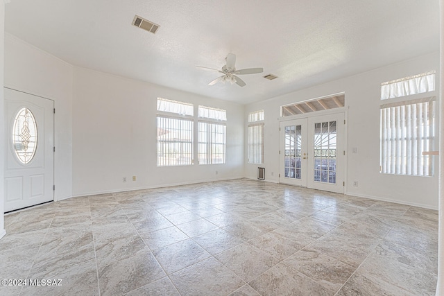 entryway with french doors, a textured ceiling, and ceiling fan