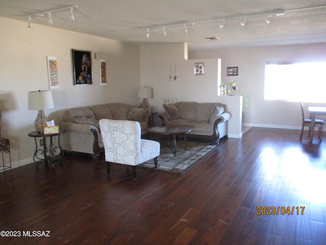 living room featuring dark hardwood / wood-style floors and rail lighting