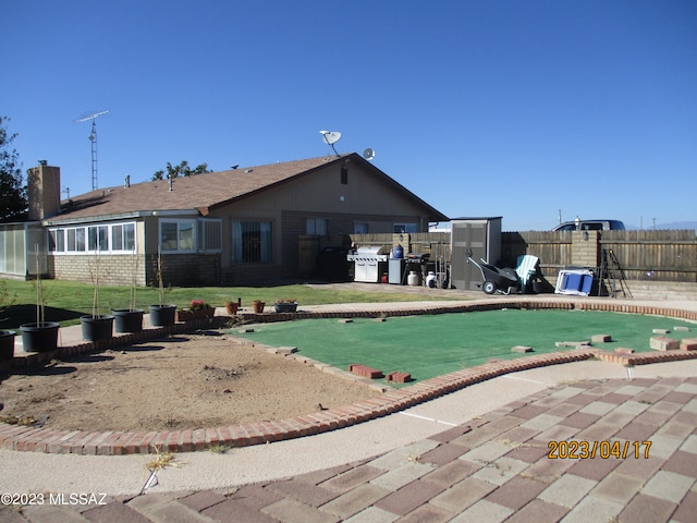 rear view of house with a patio, a fenced in pool, and a yard