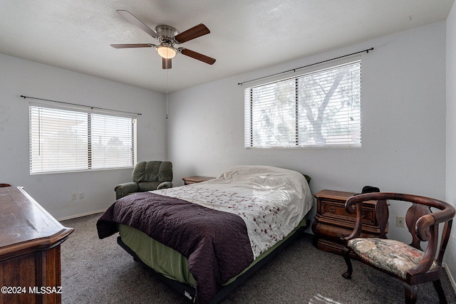 carpeted bedroom with ceiling fan and baseboards