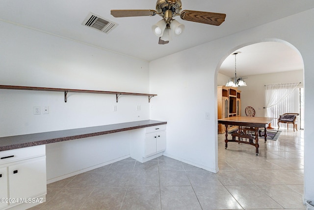 kitchen featuring arched walkways, open shelves, dark countertops, visible vents, and white cabinetry