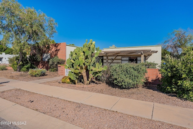 southwest-style home featuring stucco siding, fence, and a pergola