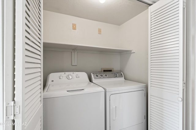 laundry room featuring washing machine and dryer and a textured ceiling