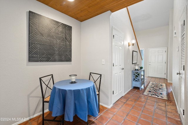 tiled dining room featuring wood ceiling