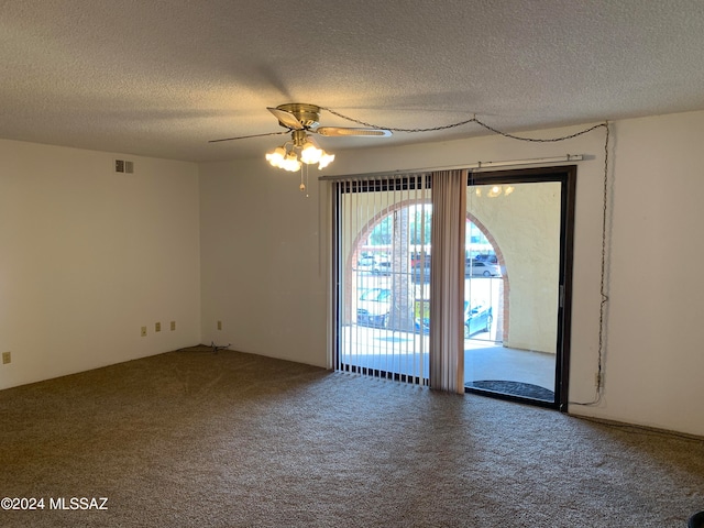 carpeted spare room featuring ceiling fan and a textured ceiling