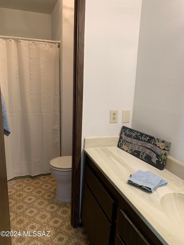 bathroom with toilet, vanity, and a shower with curtain