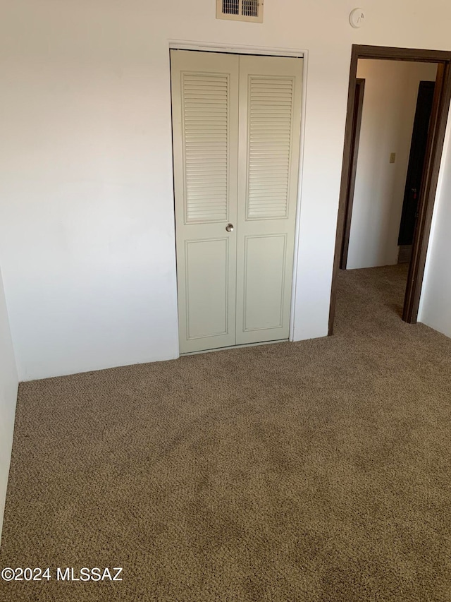 unfurnished bedroom with carpet floors and a closet