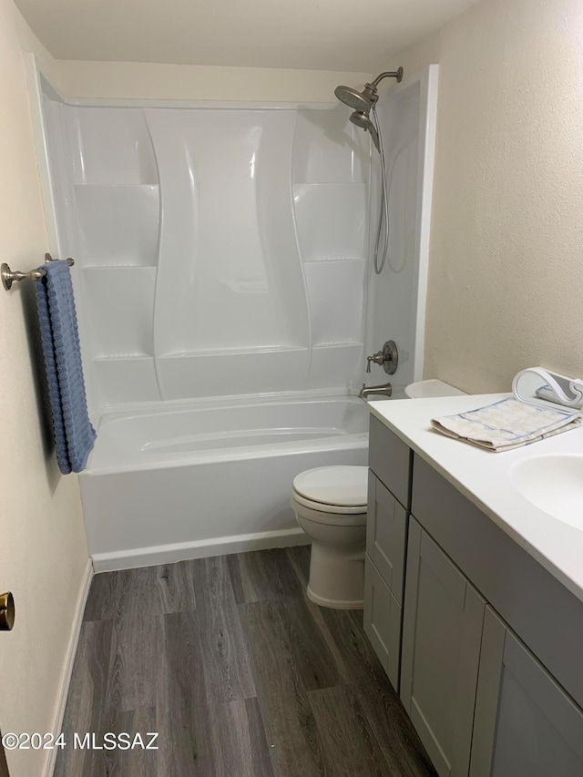 full bathroom with hardwood / wood-style floors, shower / bathing tub combination, vanity, and toilet