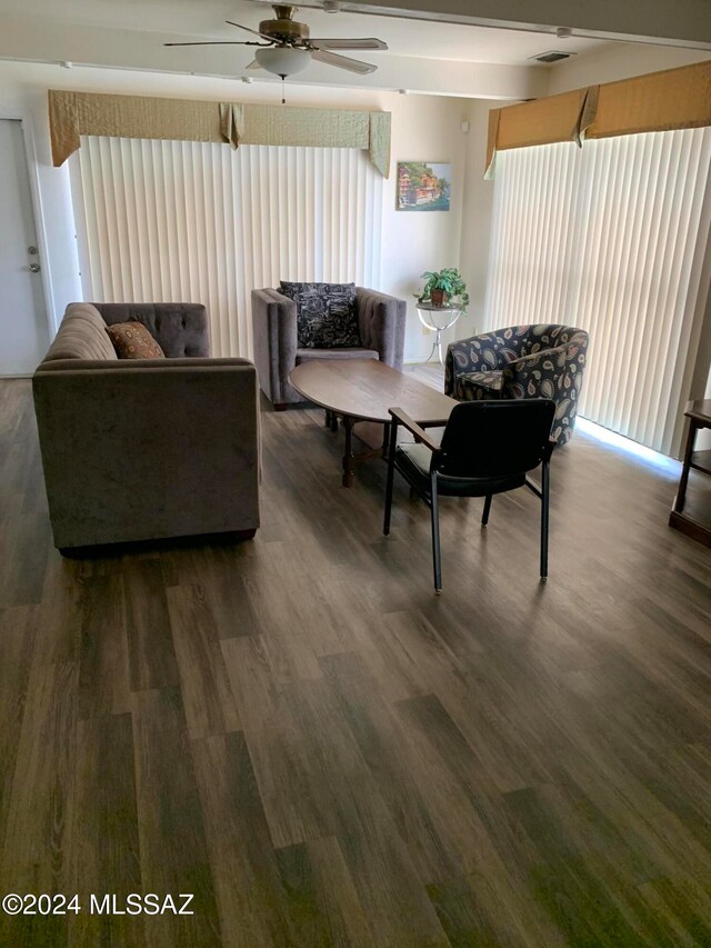 living room featuring ceiling fan and dark hardwood / wood-style flooring