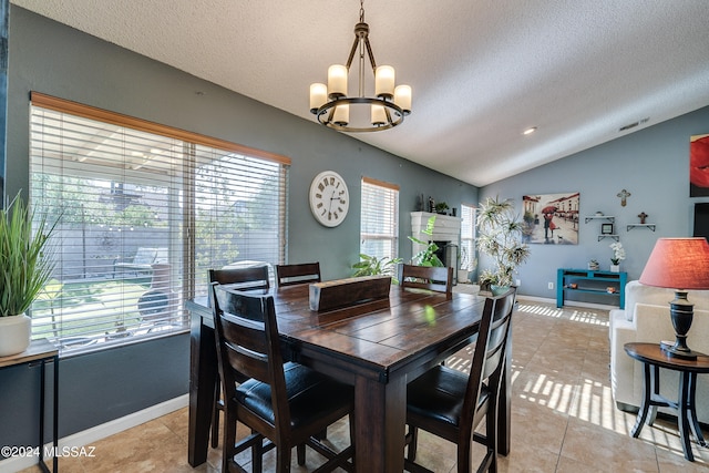 dining area with a textured ceiling, plenty of natural light, and vaulted ceiling