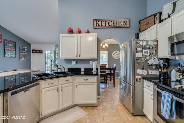 kitchen featuring sink, light tile patterned flooring, white cabinetry, stainless steel appliances, and lofted ceiling