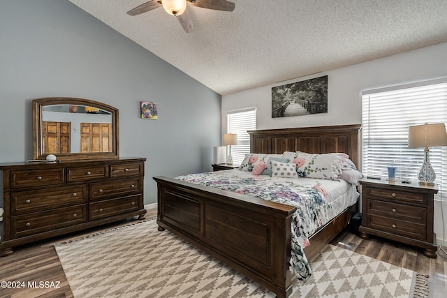 bedroom with vaulted ceiling, multiple windows, wood-type flooring, and ceiling fan