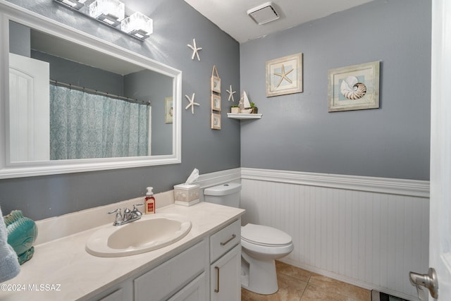 bathroom featuring vanity, toilet, and tile patterned flooring