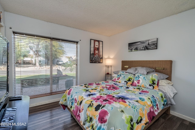 bedroom featuring a textured ceiling and dark hardwood / wood-style flooring