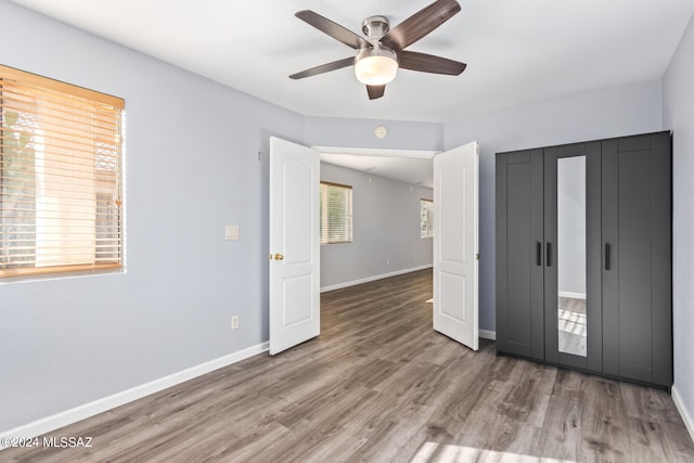 unfurnished bedroom featuring ceiling fan, hardwood / wood-style flooring, and a closet