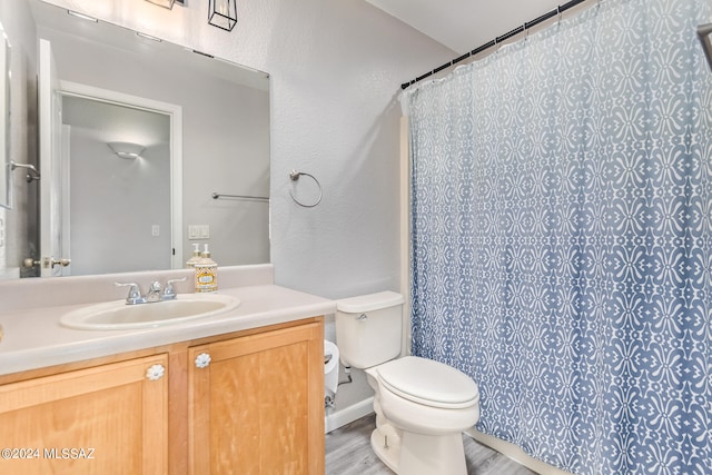 bathroom with a shower with curtain, hardwood / wood-style flooring, vanity, and toilet