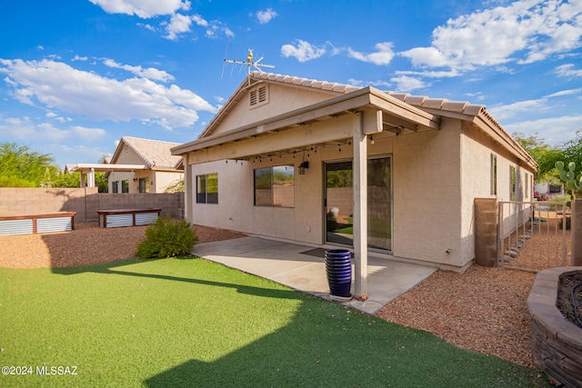 back of property with a patio and a yard