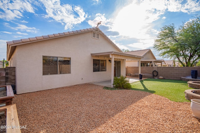 back of house with a yard and a patio