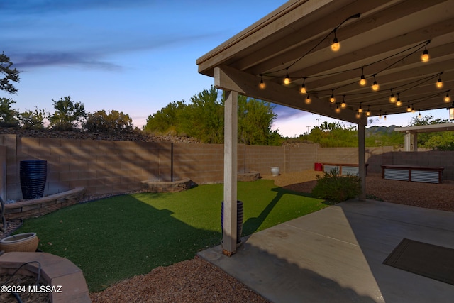 yard at dusk featuring a patio area