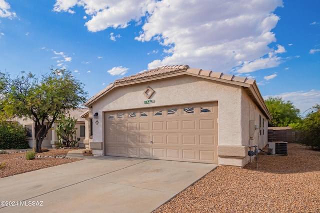 view of front of home featuring cooling unit and a garage