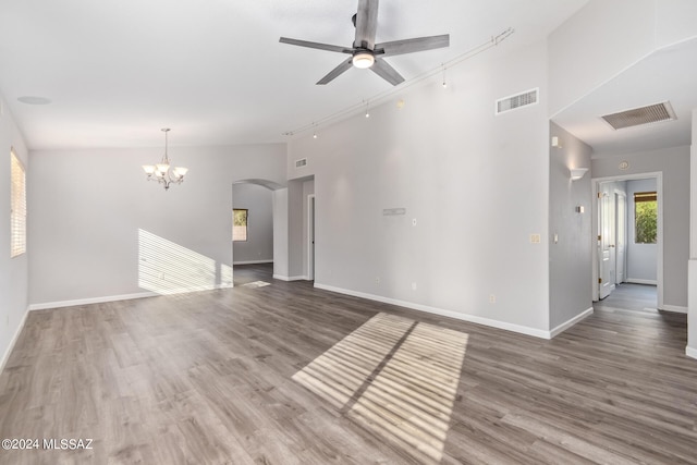 unfurnished living room featuring vaulted ceiling, dark hardwood / wood-style flooring, and ceiling fan