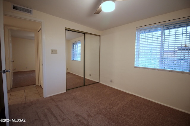 unfurnished bedroom with carpet floors, a closet, and ceiling fan