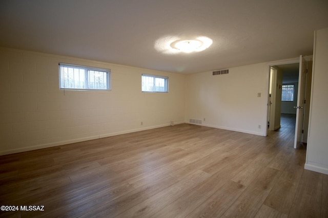 empty room with a textured ceiling and light hardwood / wood-style floors