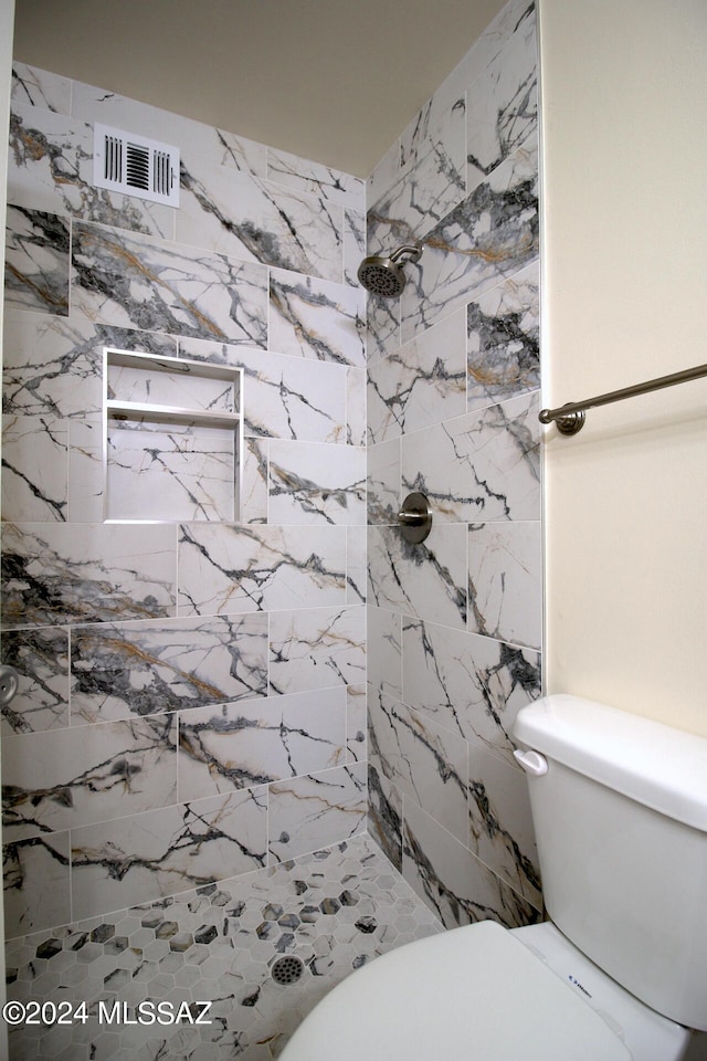 bathroom with tiled shower and toilet