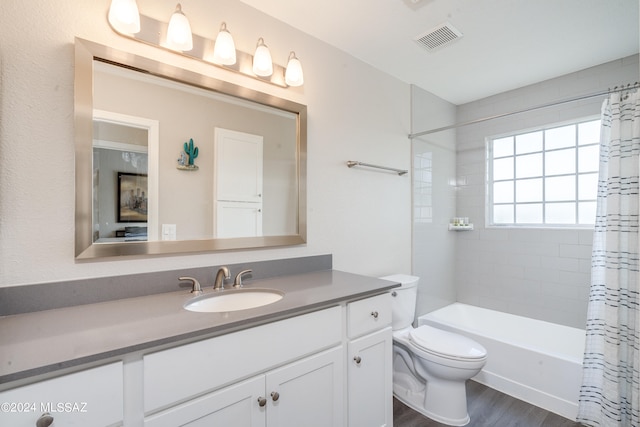 full bathroom with vanity, hardwood / wood-style floors, toilet, and shower / bathtub combination with curtain