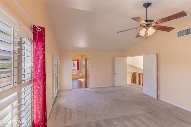 empty room with ceiling fan, lofted ceiling, and light carpet