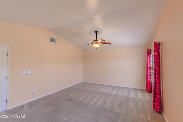 empty room featuring ceiling fan, light colored carpet, and vaulted ceiling