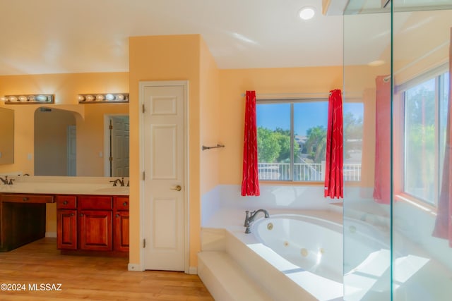 bathroom featuring vanity, a tub to relax in, and hardwood / wood-style floors