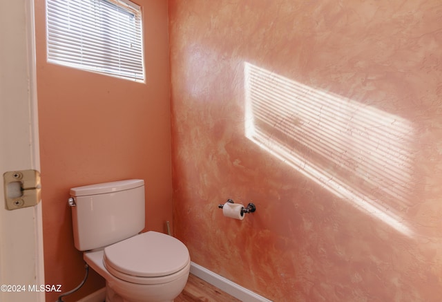 bathroom with hardwood / wood-style flooring and toilet