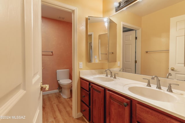 bathroom with hardwood / wood-style flooring, vanity, and toilet