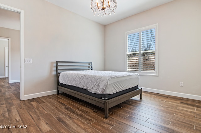 bedroom featuring a chandelier and dark hardwood / wood-style flooring