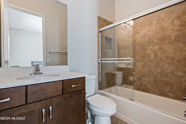 full bathroom featuring vanity, combined bath / shower with glass door, and toilet