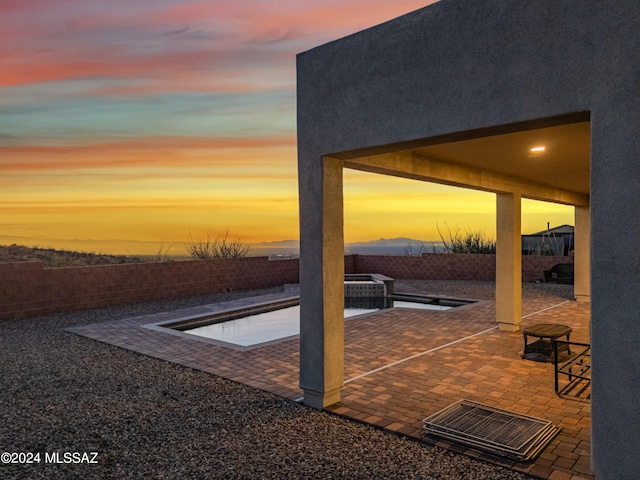 patio terrace at dusk with an in ground hot tub