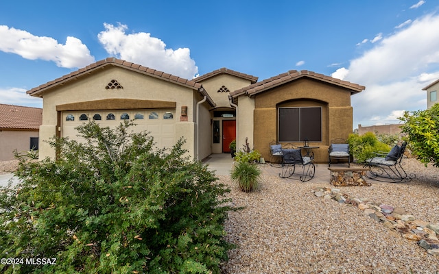 view of front of home with a garage and a patio