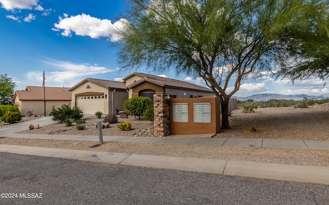 view of front of property with a garage and a mountain view