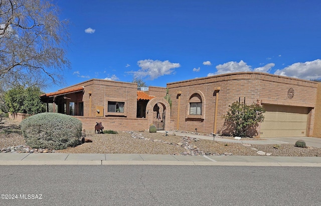 view of front of home with an attached garage, driveway, and brick siding