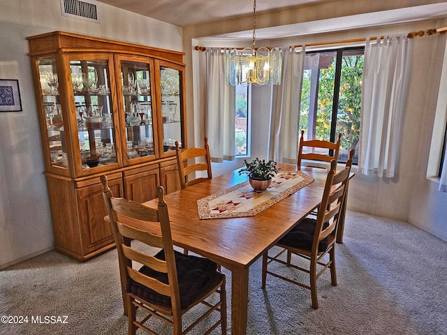 carpeted dining space with a chandelier