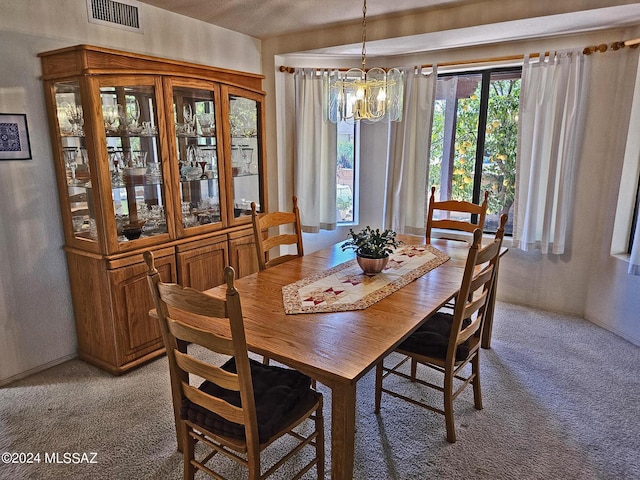 dining room with light carpet, visible vents, and an inviting chandelier
