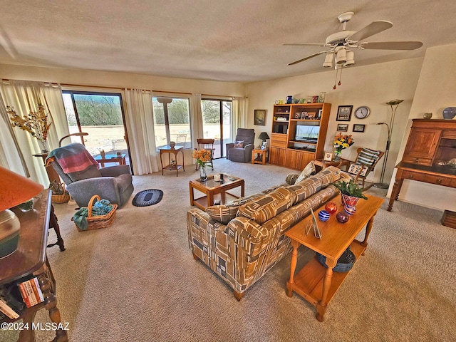 carpeted living room with ceiling fan and a textured ceiling