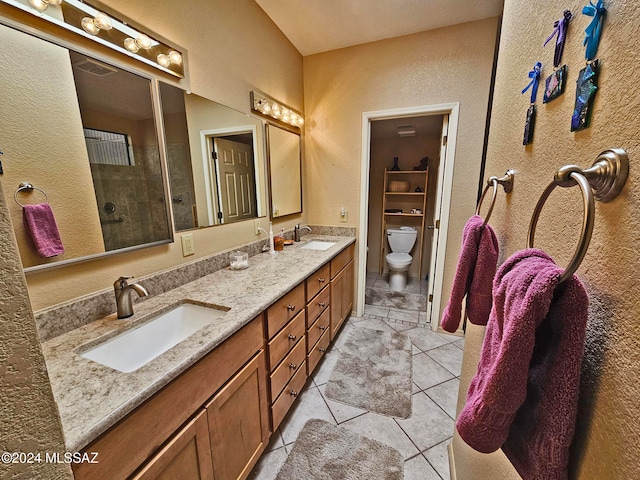 bathroom featuring vanity, tile patterned flooring, toilet, and a shower with shower door