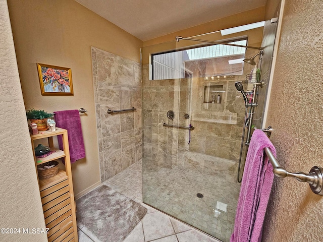 bathroom featuring a tile shower, tile patterned flooring, and a textured ceiling