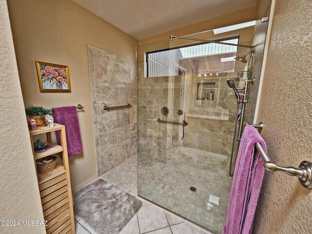 bathroom with a walk in shower and tile patterned flooring