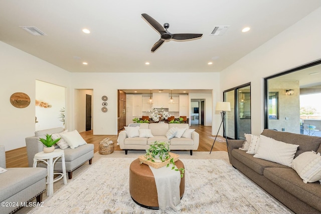 living room featuring ceiling fan and light hardwood / wood-style flooring