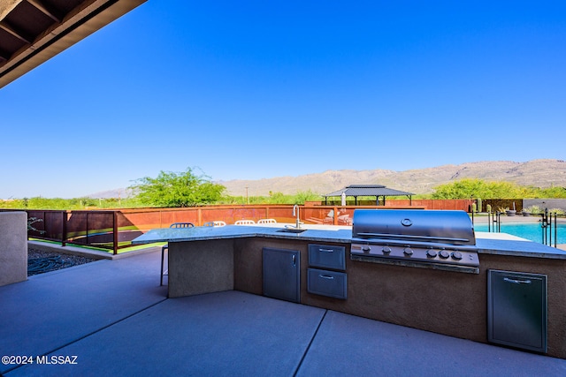 view of patio with a mountain view and a grill