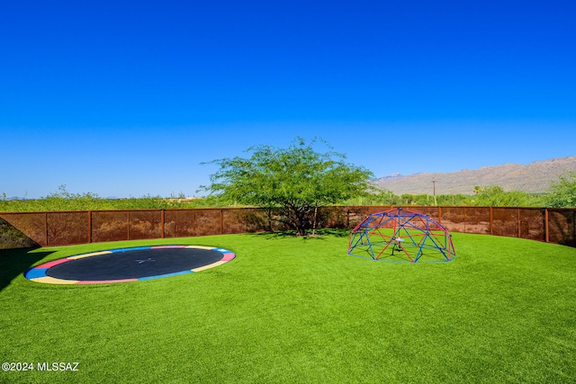 view of yard featuring a mountain view and a trampoline